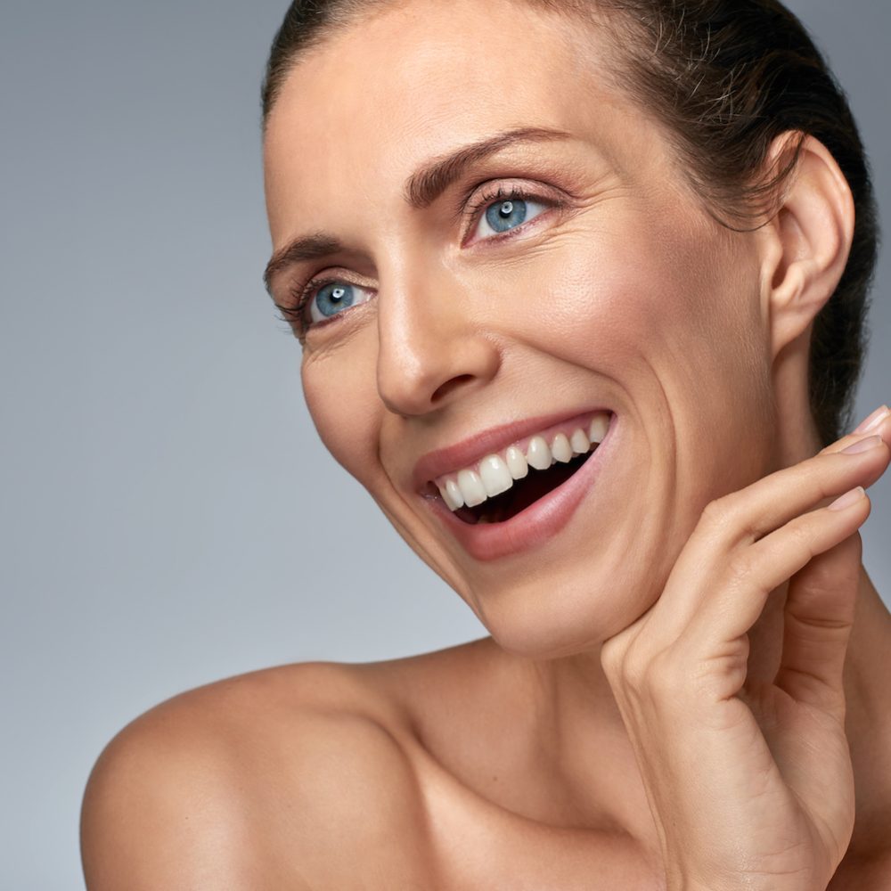 Beautiful woman laughing in studio, beauty fresh skin care concept